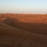 The hill sits beside a vast open desert view