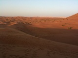 The hill sits beside a vast open desert view