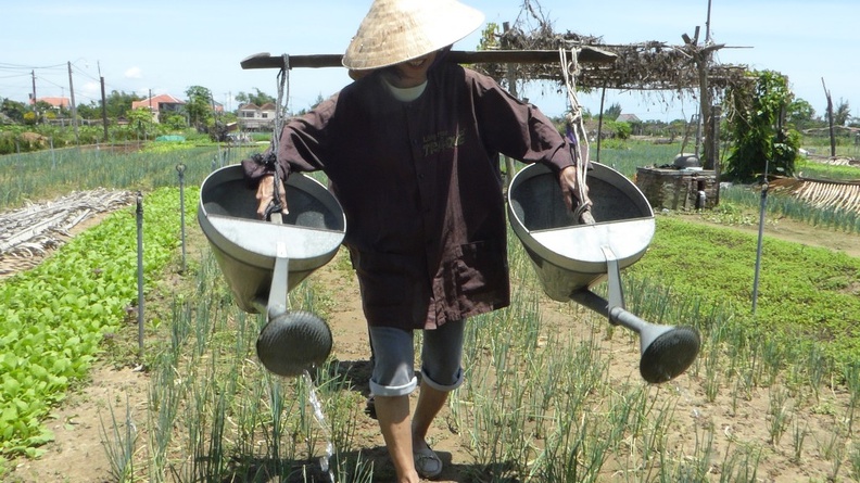 Having a go at watering cans at Hoi An Tra Que vegetable farm