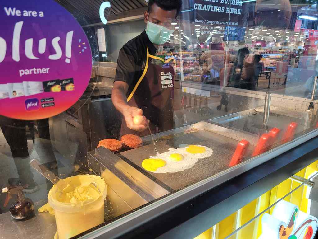 Ramly chef preparing your burgers in front of you, starting with the egg staple